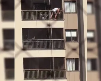 Mulher se equilibra fora de sacada no 13° andar de prédio para limpar vidro