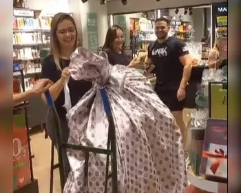 Homem se embrulha para presente e faz surpresa à namorada em shopping