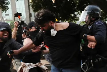 
			
				Los Angeles faz prisões em massa na 1ª noite de toque de recolher
			
			