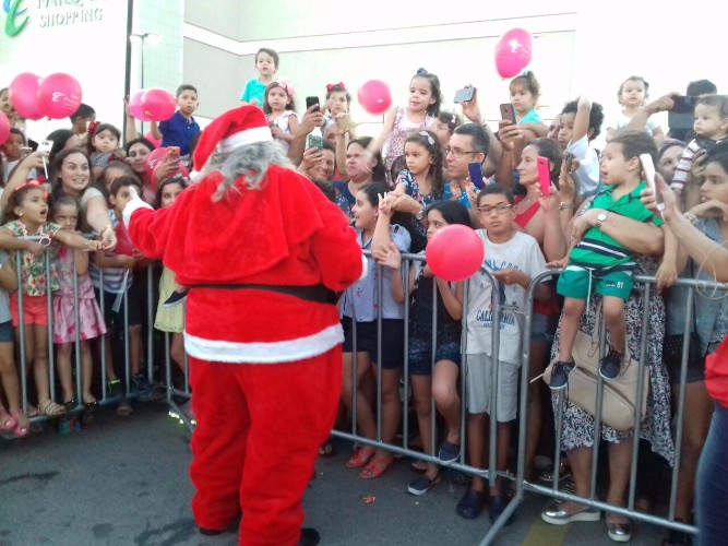 Crianças aguardam a chegada do papai noel em shopping  