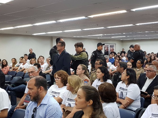 Acusado sendo levado até a cadeira de depoimento