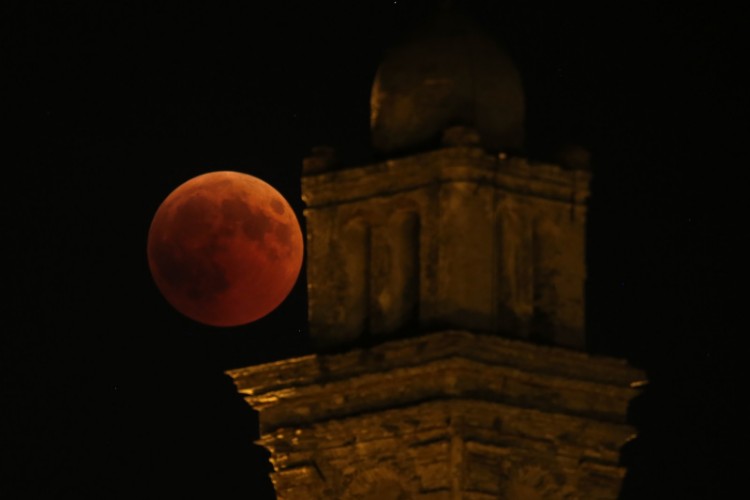 Eclipse com lua de sangue visto perto da torre de igreja em Venzolasca, França
