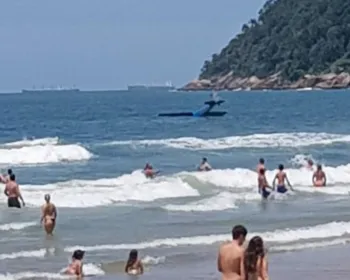 Monomotor cai no mar em praia do Guarujá, no litoral de SP