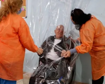 Casa geriátrica usa cortina de plástico para que famílias possam abraçar idosos