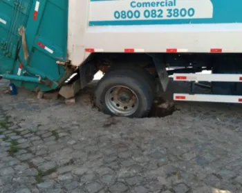 Asfalto cede e pneu de caminhão de lixo fica preso em buraco na Levada