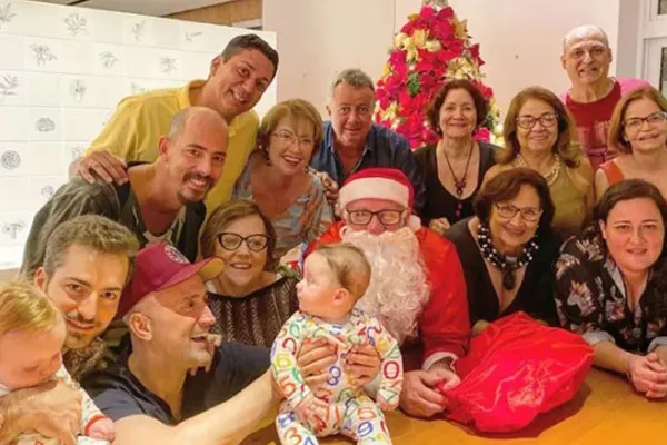 
				
					Paulo Gustavo e o marido posam com filhos gêmeos, Papai Noel e família
				
				