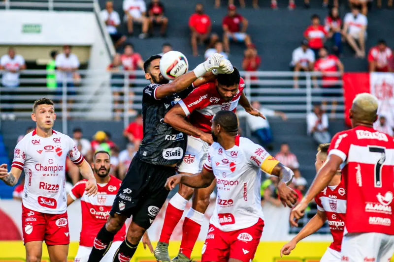 Momento de disputa acirrada de bola na área no duelo entre CRB e Vila Nova