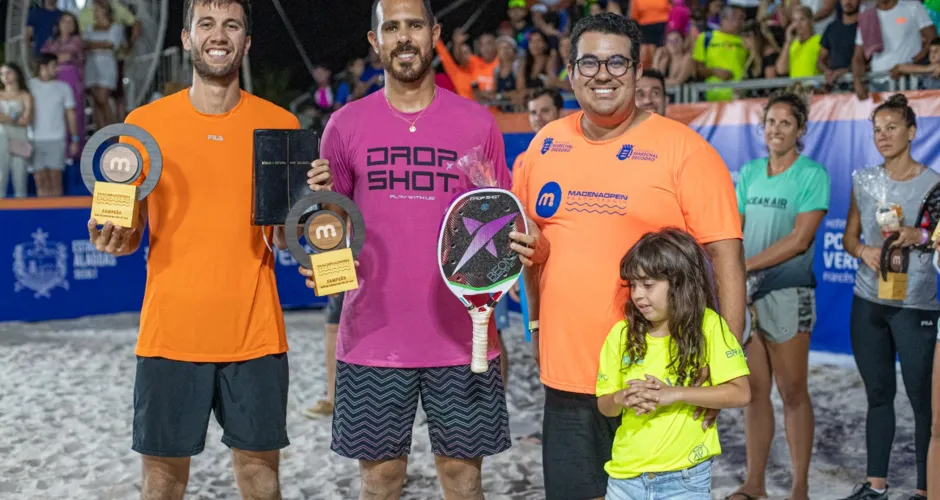 Allan Oliveira (laranja) e Thales Santos comemoram a conquista e levantam o troféu com André Macena, idealizador do evento