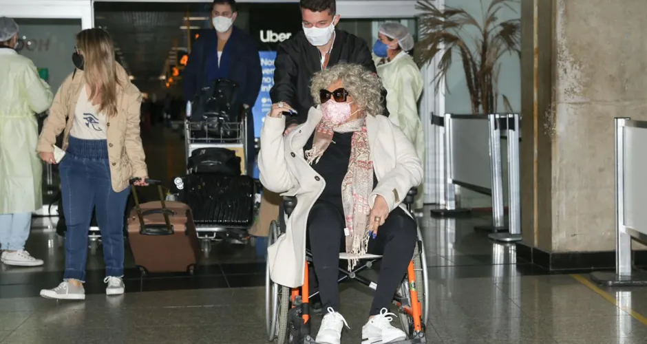 De cadeira de rodas, Alcione desembarca no aeroporto de Congonhas, em São Paulo.