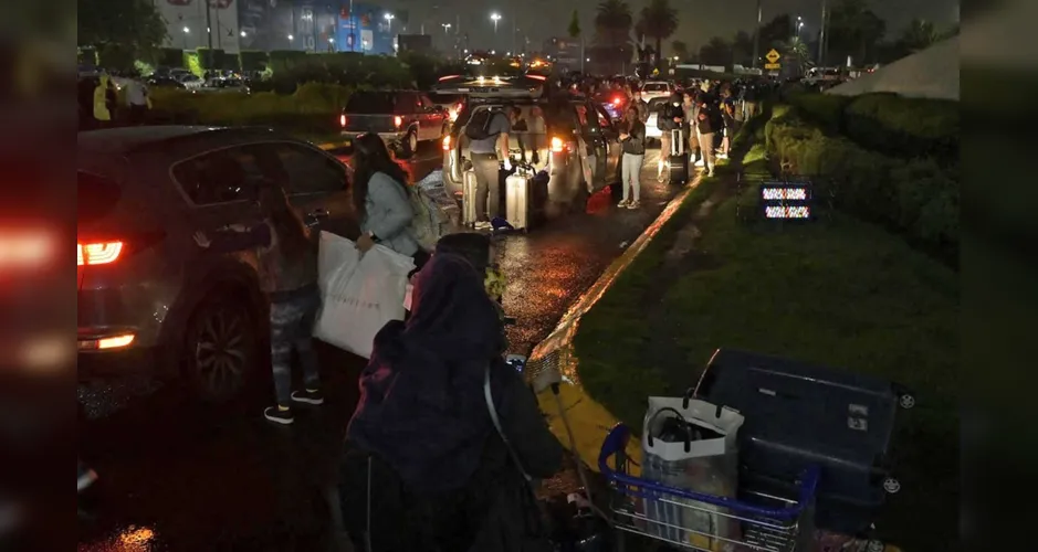 Passageiros do lado de fora do Aeroporto Internacional Benito Juarez, na Cidade do México, após o terremoto