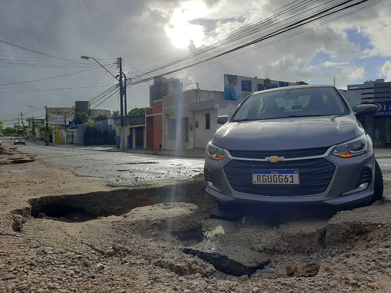 Asfalto cede e carro cai em cratera em rua no bairro do Farol, em Maceió